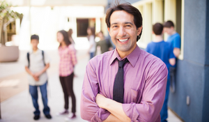 Diverse teacher posing at their school