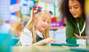 Teacher working with a younger student on a project