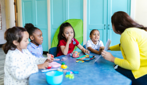 Teacher instructing young students, using techniques to transition from whole class to small group